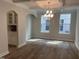 Open dining room with wood floors, coffered ceiling, modern chandelier, and built-in cabinets at 95 Black Walnut Dr # 191, Garner, NC 27529