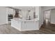 Open kitchen with white cabinets, an island with quartz countertop and stainless steel appliances at 95 Black Walnut Dr # 191, Garner, NC 27529
