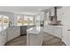 White open concept kitchen with stainless steel appliances, island and a view of the backyard through large windows at 95 Black Walnut Dr # 191, Garner, NC 27529