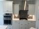 Kitchen with stainless steel oven, gas cooktop, white cabinets and geometric tile backsplash at 95 Black Walnut Dr # 191, Garner, NC 27529