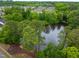 Aerial view of the community lake surrounded by lush trees and neighborhood, perfect for nature enthusiasts at 9805 Precious Stone Dr, Wake Forest, NC 27587