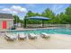 The outdoor pool is surrounded by lounge chairs and covered picnic tables for shade and relaxation at 9805 Precious Stone Dr, Wake Forest, NC 27587