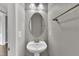 Powder room featuring gray paint and an oval mirror over a pedestal sink at 1001 Tender Dr, Apex, NC 27502