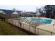 Fenced community pool area with bathhouse, featuring sun loungers and well-maintained landscaping at 1001 Tender Dr, Apex, NC 27502