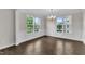 Sunlit dining room features hardwood flooring, elegant trim, and large windows with a view of lush greenery at 1001 Tender Dr, Apex, NC 27502