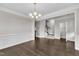Elegant dining room with dark hardwood floors, chair rail molding, and a traditional chandelier above at 1001 Tender Dr, Apex, NC 27502