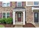 Inviting entrance with a decorative front door and manicured landscaping around the column-supported porch at 1001 Tender Dr, Apex, NC 27502