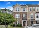 Charming townhouse exterior with stone accents, decorative shutters, and a well-manicured front lawn at 1001 Tender Dr, Apex, NC 27502
