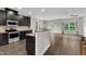 Open-concept kitchen with dark cabinets, granite countertops, stainless steel appliances, and a breakfast bar at 1001 Tender Dr, Apex, NC 27502