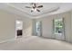 Spacious main bedroom featuring tray ceilings, windows, and an en suite bathroom at 1001 Tender Dr, Apex, NC 27502