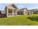 Backyard view with lush lawn, concrete patio, screened porch, and home exterior with siding and windows at 1009 Middleground Cir, Durham, NC 27713
