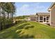 Backyard with green lawn, concrete patio, screened porch, and view of the home's exterior with siding at 1009 Middleground Cir, Durham, NC 27713
