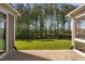 View of the backyard showcasing lush green lawn and an abundance of trees as seen from concrete patio at 1009 Middleground Cir, Durham, NC 27713