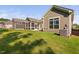 Backyard view with well-manicured lawn, exterior home features, concrete patios, and screened-in back porch at 1009 Middleground Cir, Durham, NC 27713