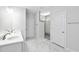 Modern bathroom featuring double sinks, white cabinetry, marble countertops, and marble floors for a luxurious experience at 1009 Middleground Cir, Durham, NC 27713