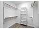 Bright walk-in closet features custom shelving and wooden rods for ample storage space and organization at 1009 Middleground Cir, Durham, NC 27713