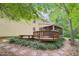 Backyard with a wooden deck and screened porch overlooking a landscaped yard and stone path at 106 Shady Point Ct, Durham, NC 27713