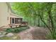 Charming backyard with a wooden deck, screened porch, stone path, and lush landscaping at 106 Shady Point Ct, Durham, NC 27713
