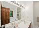 Bright bathroom featuring double sinks, a large mirror, and a jetted tub with a nature view at 106 Shady Point Ct, Durham, NC 27713