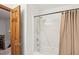 Bathroom showing tub with shower head, and a wooden door adjacent to the bath stall at 106 Shady Point Ct, Durham, NC 27713