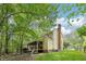 Exterior view of home with a screened porch, deck, and lush green yard surrounded by mature trees at 106 Shady Point Ct, Durham, NC 27713