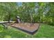 Community playground with swings, slides, and climbing structures in a safe, wooded area at 106 Shady Point Ct, Durham, NC 27713