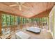 Enclosed porch featuring a hot tub, wood ceiling, and large windows at 106 Shady Point Ct, Durham, NC 27713