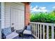 Private balcony with seating, featuring blue patterned cushions and a view of lush greenery at 107 Sturbridge Dr, Clayton, NC 27520