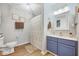 Well-lit bathroom featuring a blue vanity, modern fixtures, and a patterned shower curtain at 107 Sturbridge Dr, Clayton, NC 27520