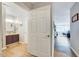 Bathroom doorway view showcases a vanity, and living space with a large sofa and windows at 107 Sturbridge Dr, Clayton, NC 27520