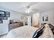 Well-lit bedroom features wooden floors, a ceiling fan, a dresser, and a view into the hallway and closets at 107 Sturbridge Dr, Clayton, NC 27520