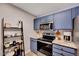 The kitchen includes stainless steel appliances, a microwave, stylish cabinets, and a view of the bathroom at 107 Sturbridge Dr, Clayton, NC 27520
