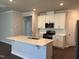 Modern kitchen boasts white cabinets, stainless appliances, and a large island with seating at 1080 River Glade Ct # 17, Graham, NC 27253