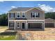 Charming two-story home featuring neutral siding, dark shutters, and an attached two-car garage, complemented by an extra detached garage at 109 Sagamore Avenue, Angier, NC 27501