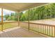 Covered back porch overlooking a large backyard area with wooden railings and a wooded treeline beyond at 1112 Prominence Dr, Durham, NC 27712