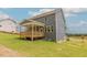 The property boasts a charming wooden porch and a large, well-kept backyard, perfect for relaxing or entertaining outdoors at 1112 Prominence Dr, Durham, NC 27712