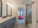 Bathroom boasts double vanity with a large mirror and walk-in glass shower with wood-look tile at 1112 Prominence Dr, Durham, NC 27712