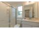 This well-lit bathroom features a glass shower, a toilet, and a vanity with a large mirror at 1112 Prominence Dr, Durham, NC 27712