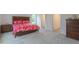 Bright bedroom featuring a wooden bed frame, vibrant floral bedding, and soft gray carpet at 1112 Prominence Dr, Durham, NC 27712