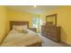 Bedroom with yellow walls, carpeted floors, and a full size bed with a green and white comforter at 1112 Prominence Dr, Durham, NC 27712