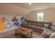 Upstairs bonus room with decorative hexagonal wall, large sectional, and window with backyard view at 1112 Prominence Dr, Durham, NC 27712