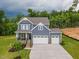 Beautiful two-story home with a lush green lawn, a three car garage, and lovely landscaping at 1112 Prominence Dr, Durham, NC 27712