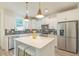 Well-lit kitchen with stainless steel appliances, white cabinets, a quartz island, and a farm style sink at 1112 Prominence Dr, Durham, NC 27712
