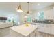 Open kitchen featuring white cabinets, stainless steel appliances and an island, with an adjacent living room area at 1112 Prominence Dr, Durham, NC 27712