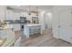 Well-lit kitchen with white cabinets, stainless steel appliances, and an island with bar stools at 1112 Prominence Dr, Durham, NC 27712