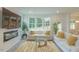 Comfortable living room with a fireplace, TV, white sofas, and a view of the outdoor greenery at 1112 Prominence Dr, Durham, NC 27712