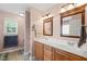 Well-lit bathroom with a double sink vanity, tiled floors, and a separate toilet area at 112 Nelson Ln, Clayton, NC 27527