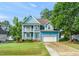 Charming two-story blue home featuring a double front porch, attached garage, and well-manicured lawn at 112 Nelson Ln, Clayton, NC 27527