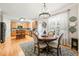 Sunlit kitchen with wood cabinets, a circular dining table with chandelier, and stainless steel appliances at 112 Nelson Ln, Clayton, NC 27527