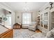 Well-decorated living room featuring a chandelier, accent chairs, built-in shelving and a plush area rug at 112 Nelson Ln, Clayton, NC 27527